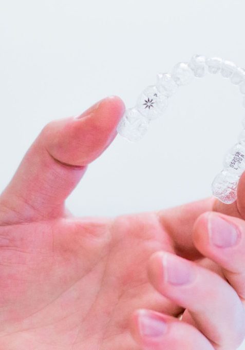 hand-holding-invisalign-aligners Invisalign for Teens
